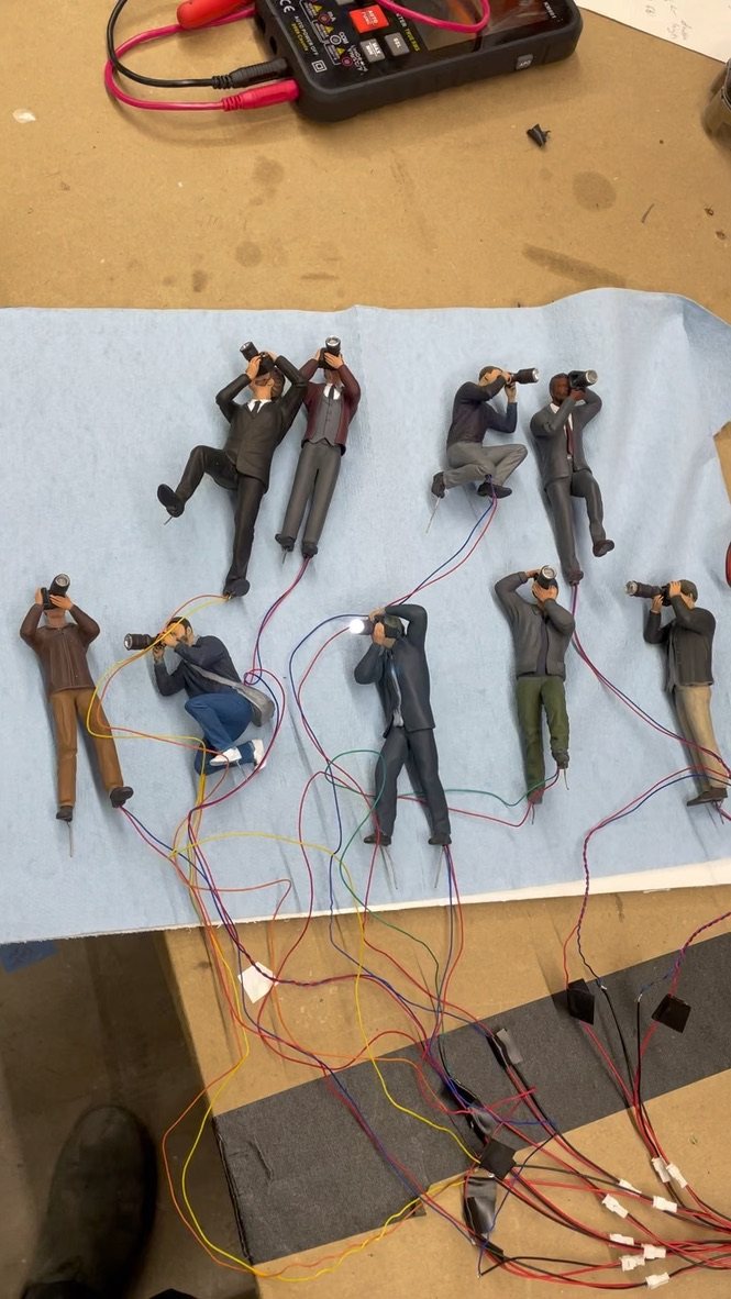 Miniature photographers being wired on the bench