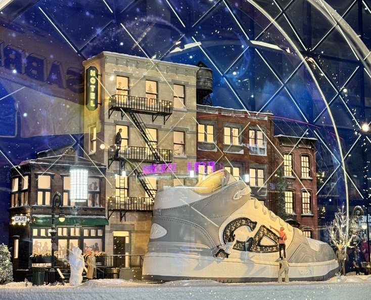 Sneaker window with a snowy city block behind it