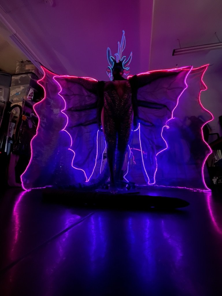 Illuminated winged costume in workshop
